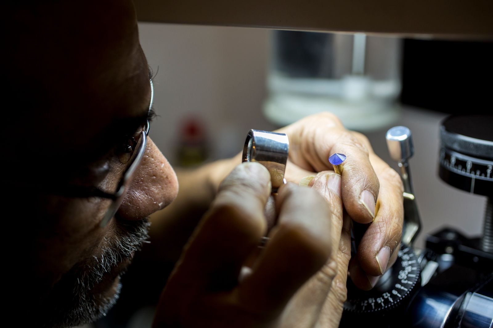 Gemmologue examinant une pierre à la loupe
